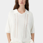 Cream knit polo top with collar, V neckline, and vertical lace panel detailing
