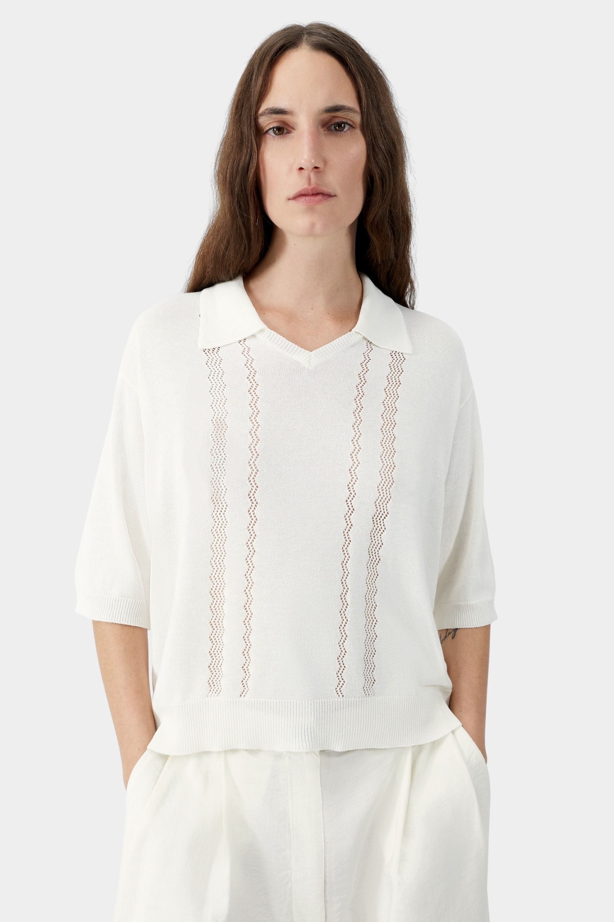 Cream knit polo top with collar, V neckline, and vertical lace panel detailing
