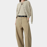 Beige flecked knit cardigan worn open with relaxed trousers and sandals