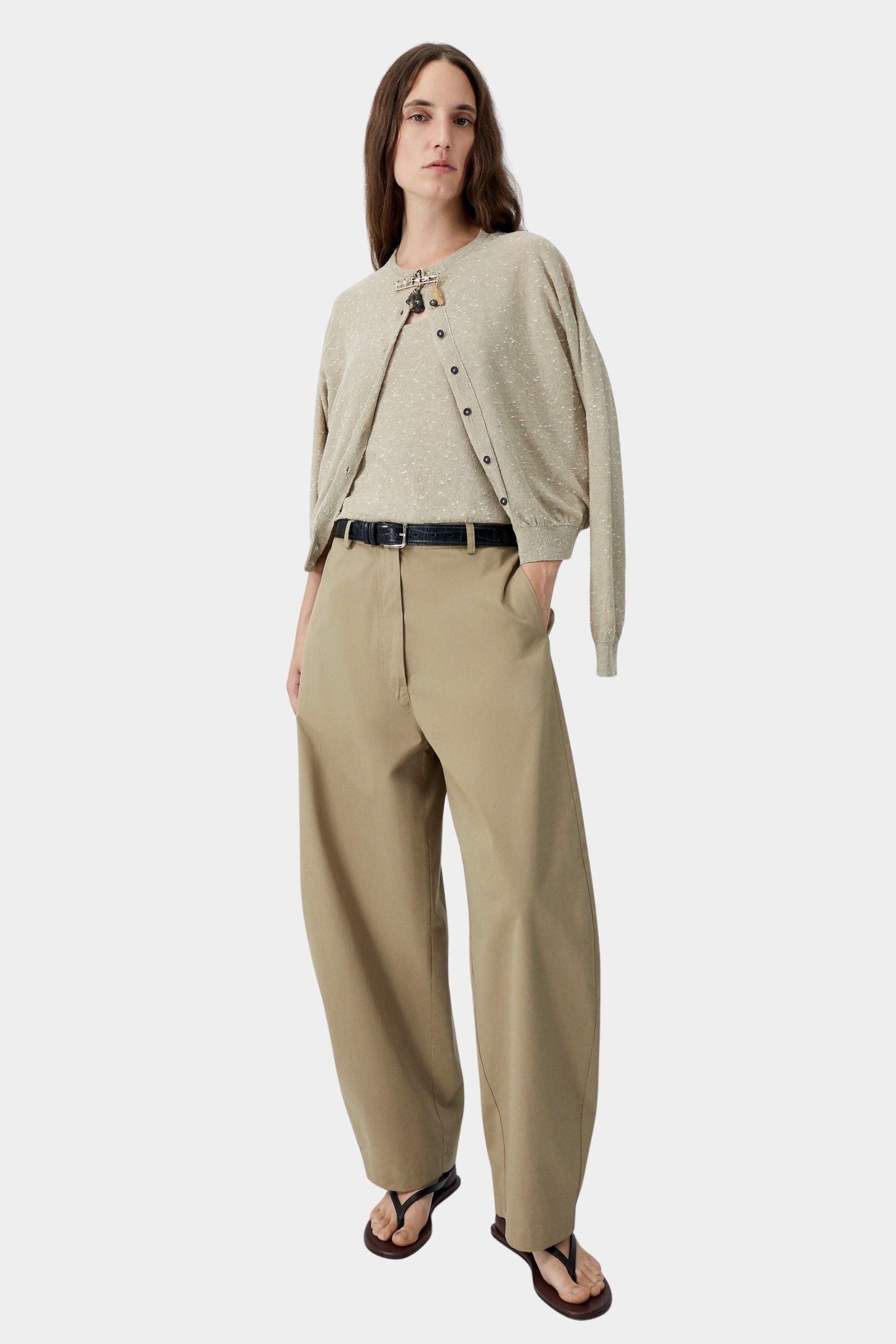 Beige flecked knit cardigan worn open with relaxed trousers and sandals