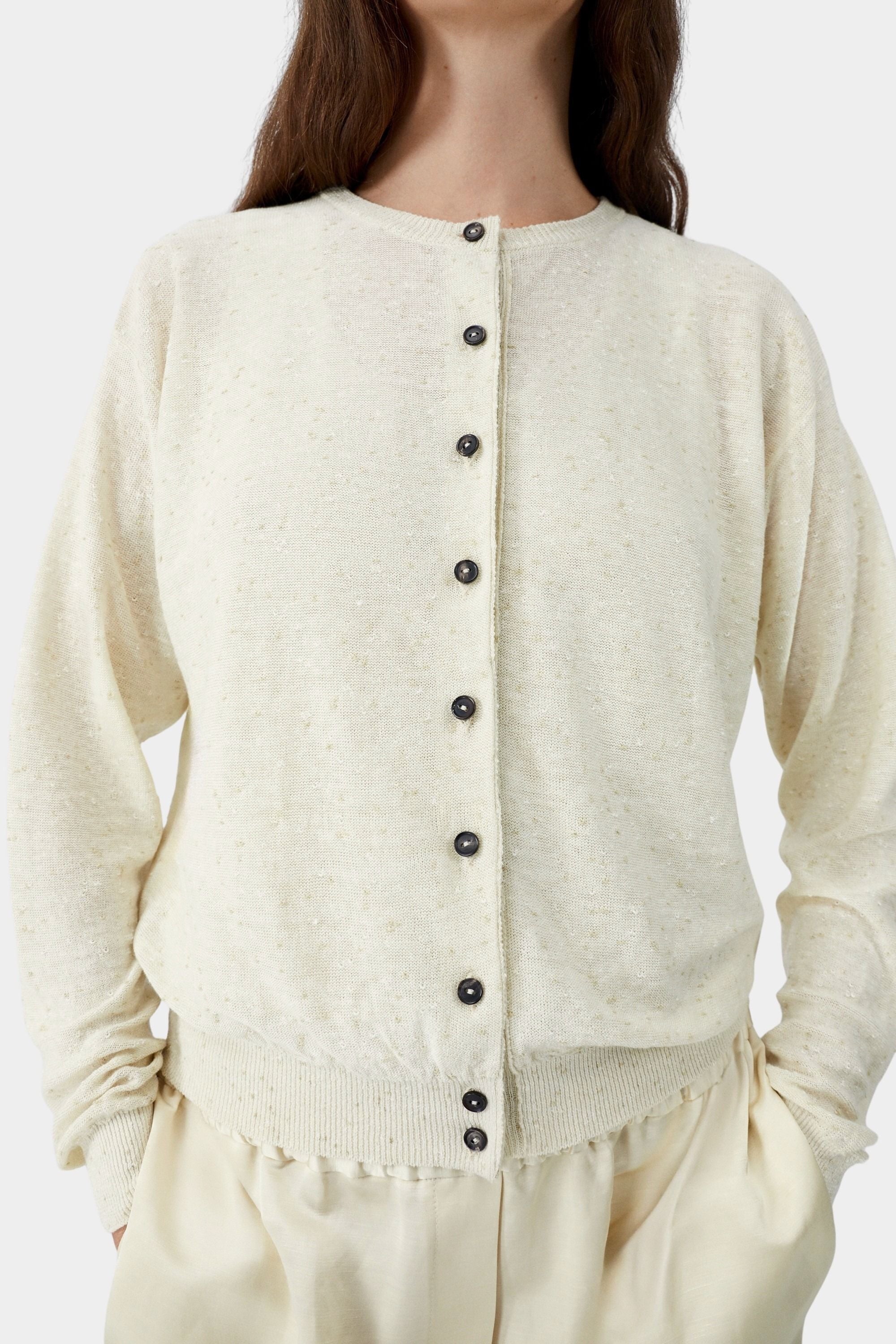 Cream flecked knit cardigan with button front closure and subtle texture