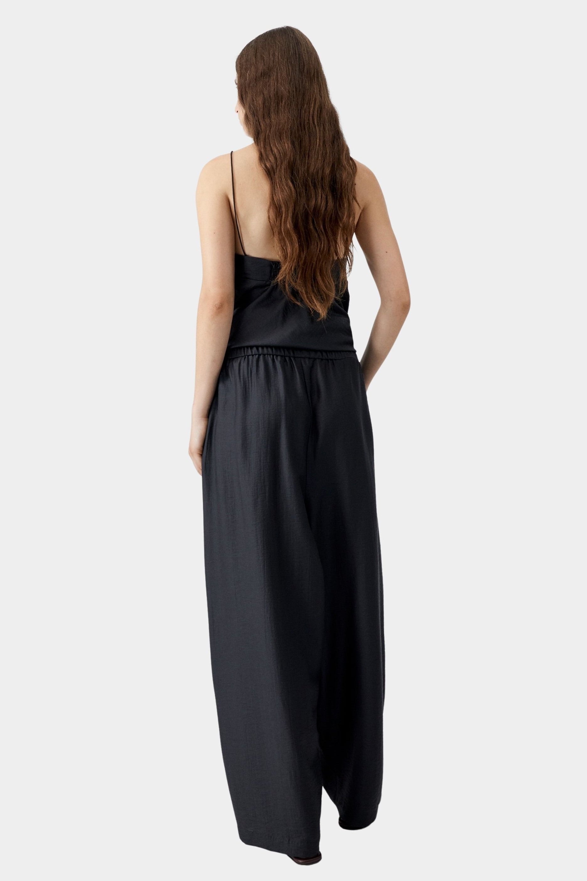 Black maxi pants with elastic waistband and relaxed wide leg silhouette, worn with matching top