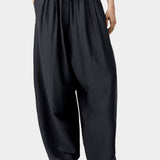 Black wide leg pants with elastic waist and drawstring detail, showing soft volume and drape
