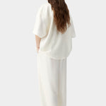 Cream maxi pants with elastic waistband and relaxed wide leg silhouette, worn as matching set