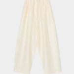 Cream maxi pants with elastic waistband, drawstring closure, and wide leg silhouette