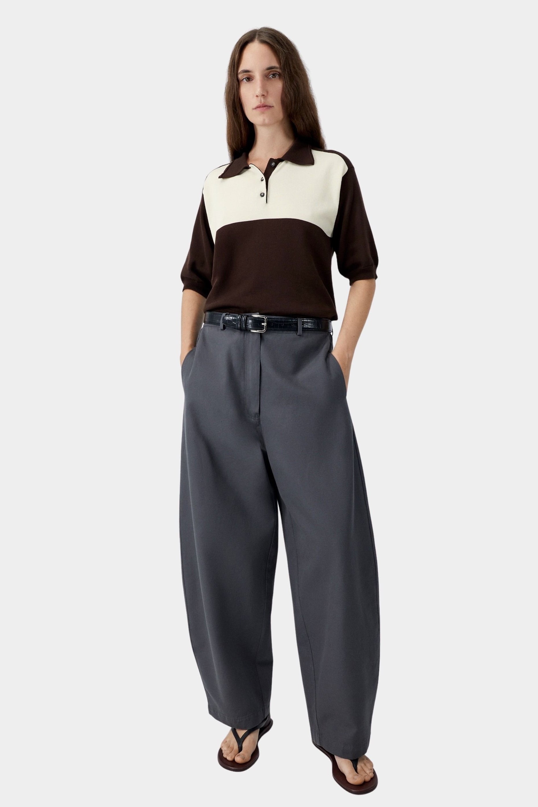 Brown and cream colorblock polo with relaxed fit and short sleeves, worn with grey tailored pants and sandals