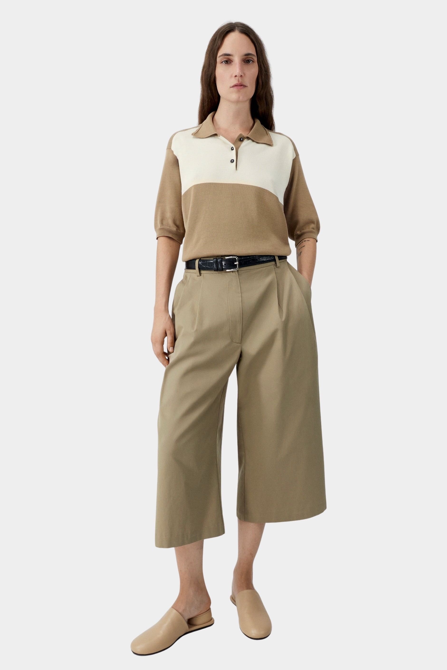 Camel and cream colorblock polo with relaxed fit and short sleeves, worn with khaki wide leg trousers and flats