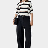 Organic cotton striped polo worn with dark trousers and minimal sandals