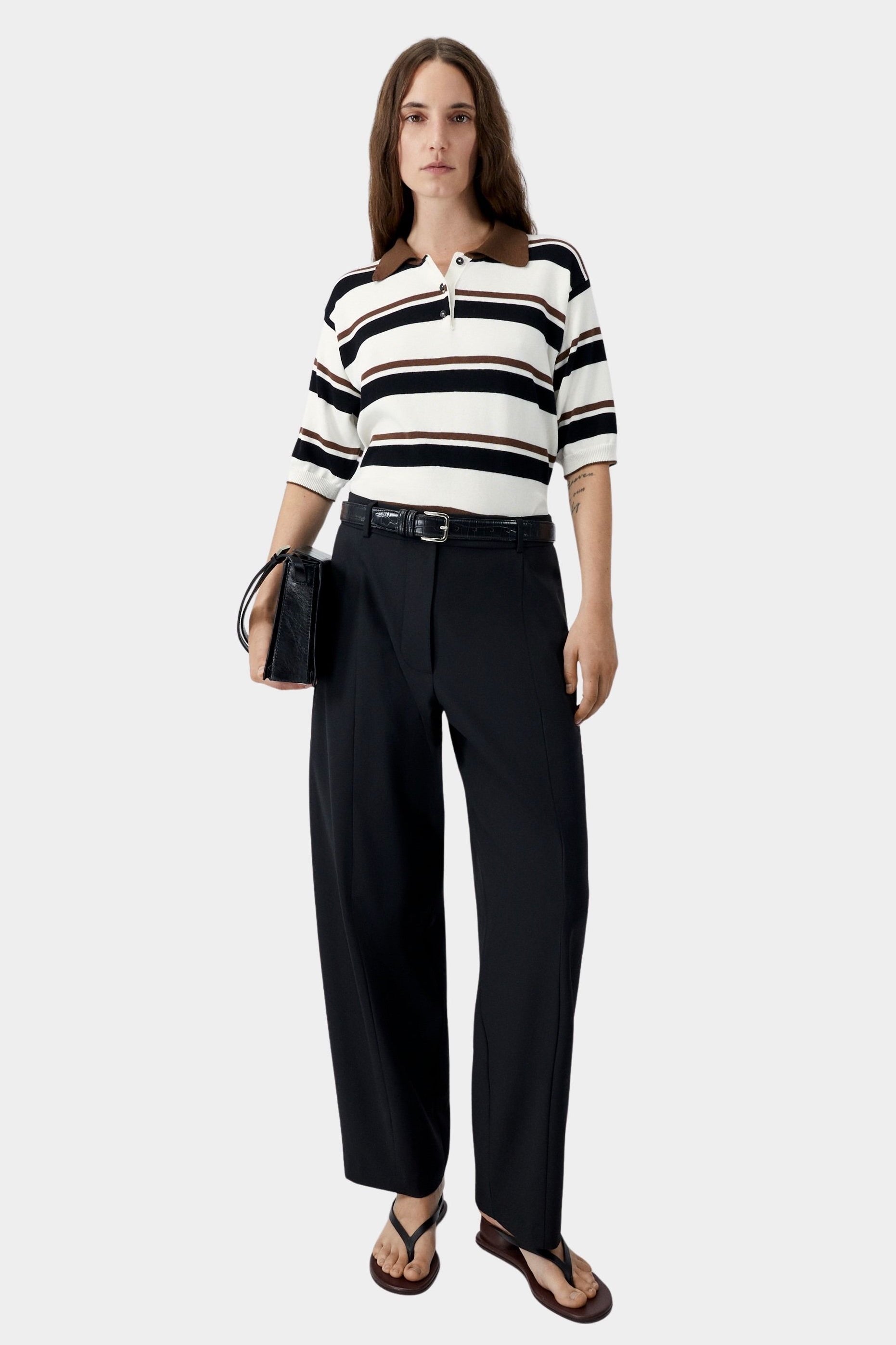 Organic cotton striped polo worn with dark trousers and minimal sandals
