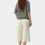 Cordera organic cotton V-neck polo in black and cream stripe, back view showing relaxed drape, short sleeves, and clean structure