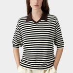 Cordera organic cotton V-neck polo in black and cream stripe, close-up showing soft knit texture, contrast collar, and relaxed neckline