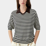 Cordera organic cotton V-neck polo in black and cream stripe, close-up showing soft knit texture, contrast collar, and relaxed neckline