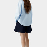 Light blue oversized shirt with relaxed drape and curved hem