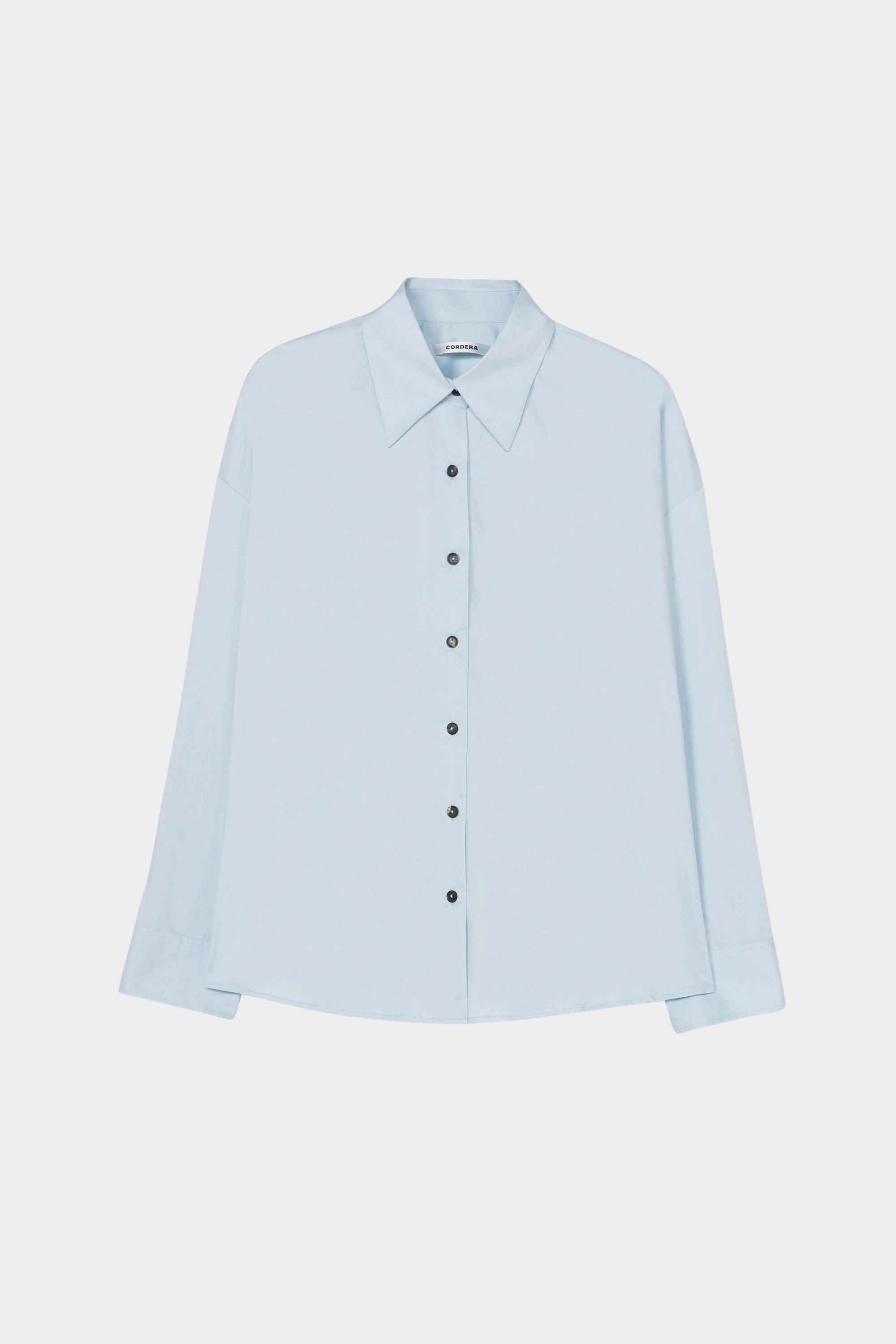 Light blue oversized button-down shirt with pointed collar and black buttons