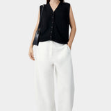 Black oversized waistcoat worn with wide leg trousers and shoulder bag