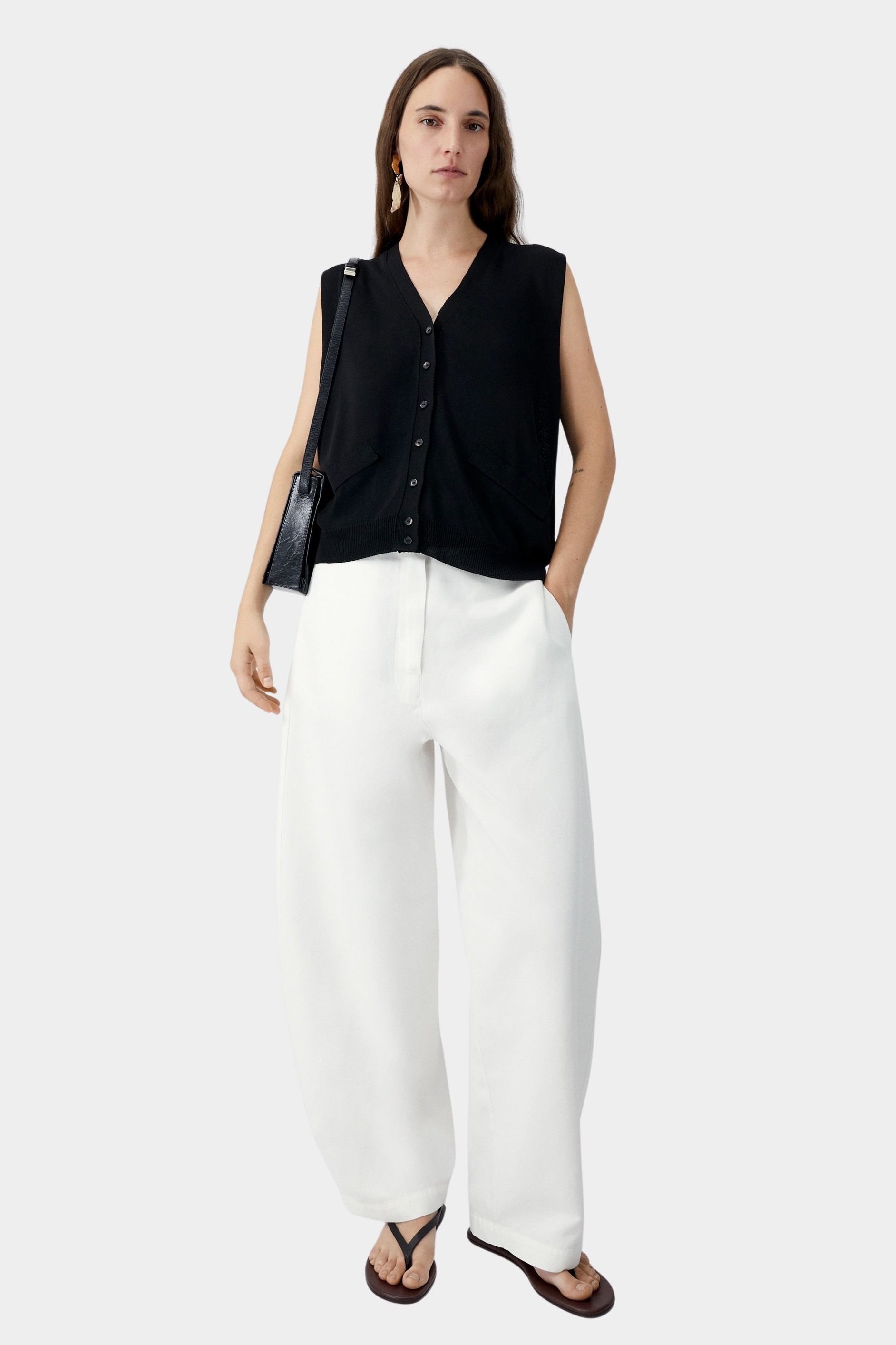 Black oversized waistcoat worn with wide leg trousers and shoulder bag