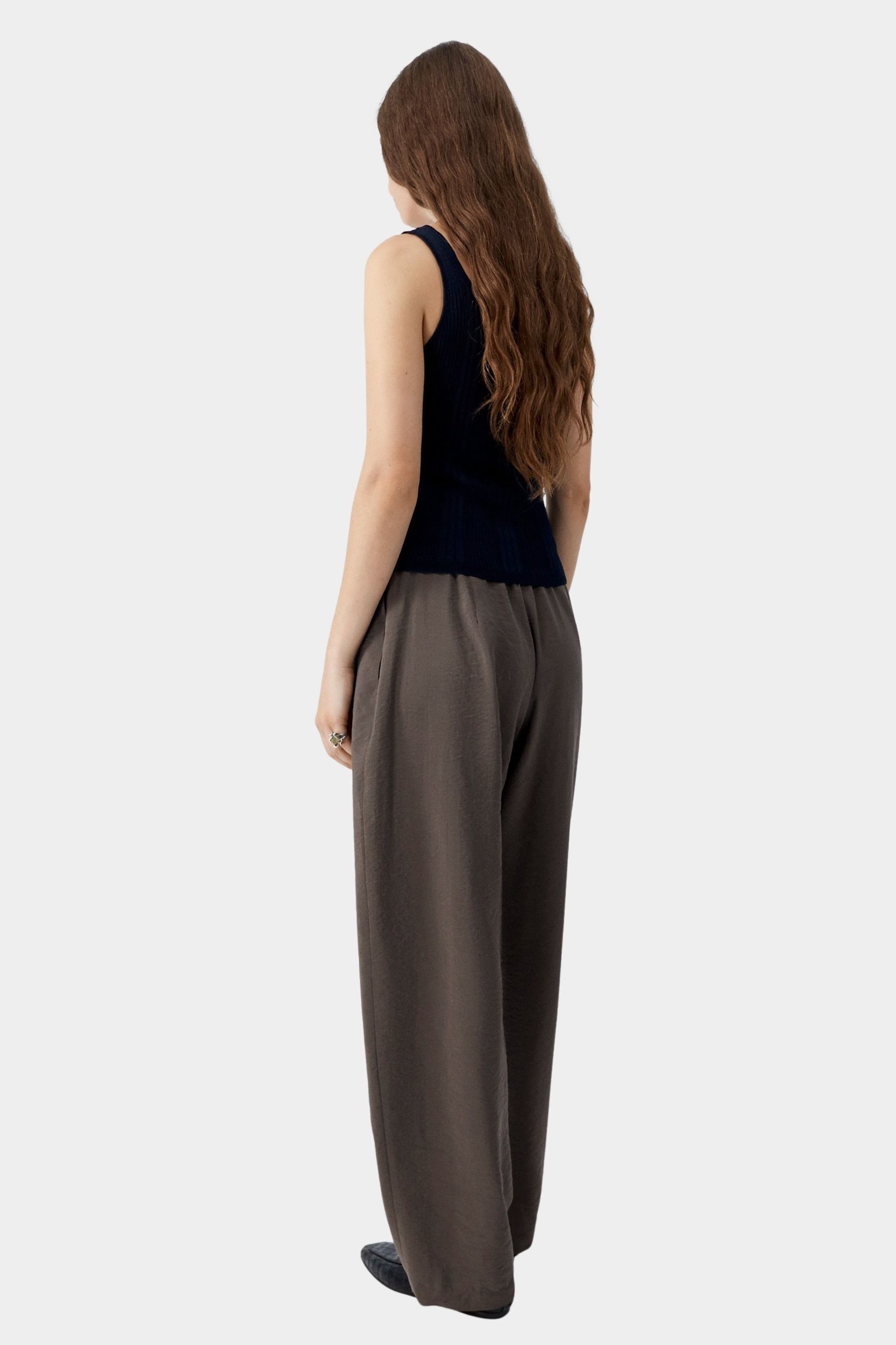 Navy ribbed knit tank top with fitted silhouette and clean back, worn with tailored trousers