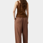 Brown ribbed knit tank top with fitted shape and clean back, worn with fluid trousers