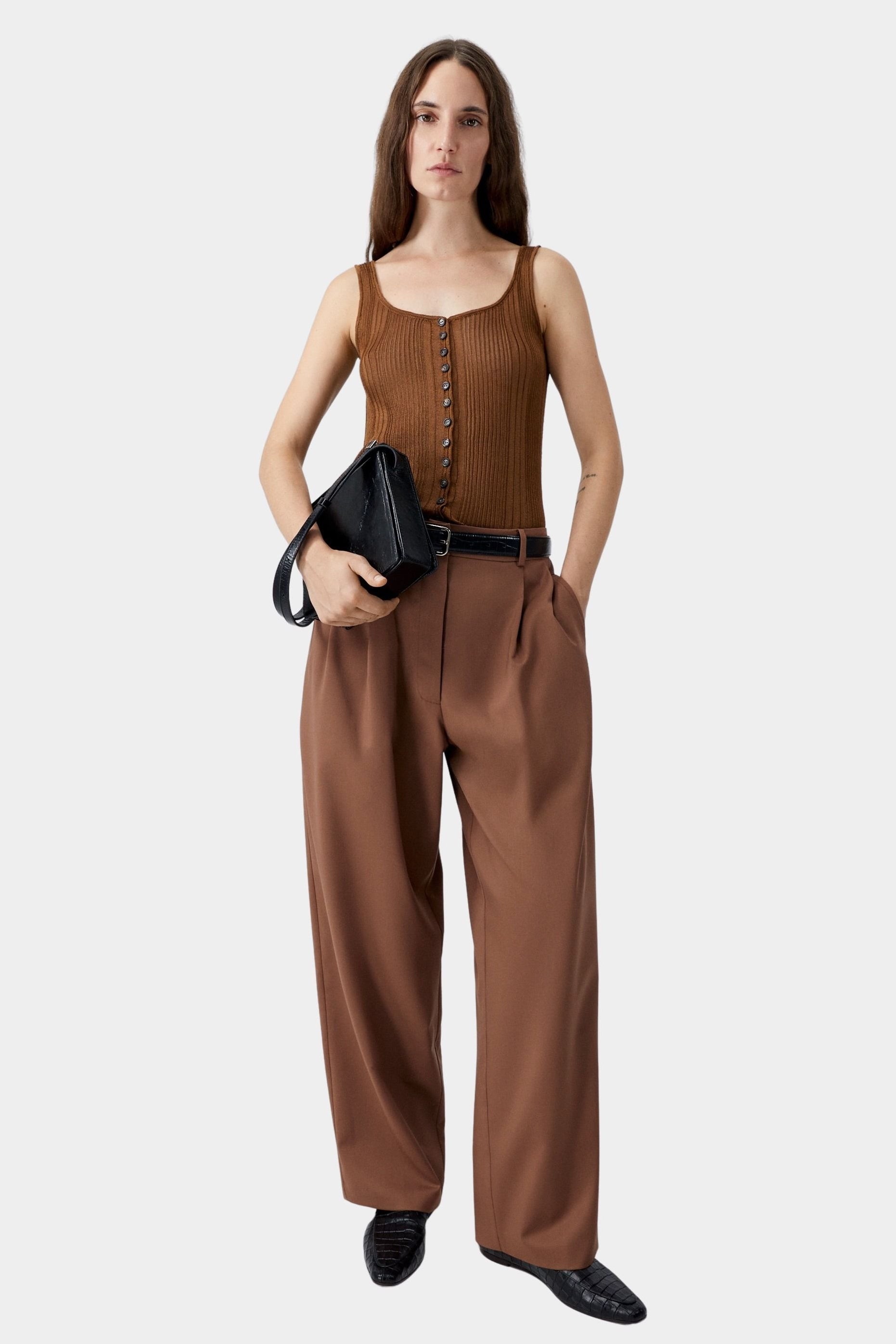 Brown ribbed button-front tank top worn with wide leg trousers and black belt, relaxed tailored styling