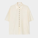 Cream short sleeve button-up shirt with pointed collar, boxy silhouette, and lightweight textured fabric