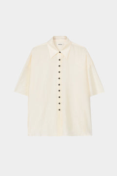 Cream short sleeve button-up shirt with pointed collar, boxy silhouette, and lightweight textured fabric
