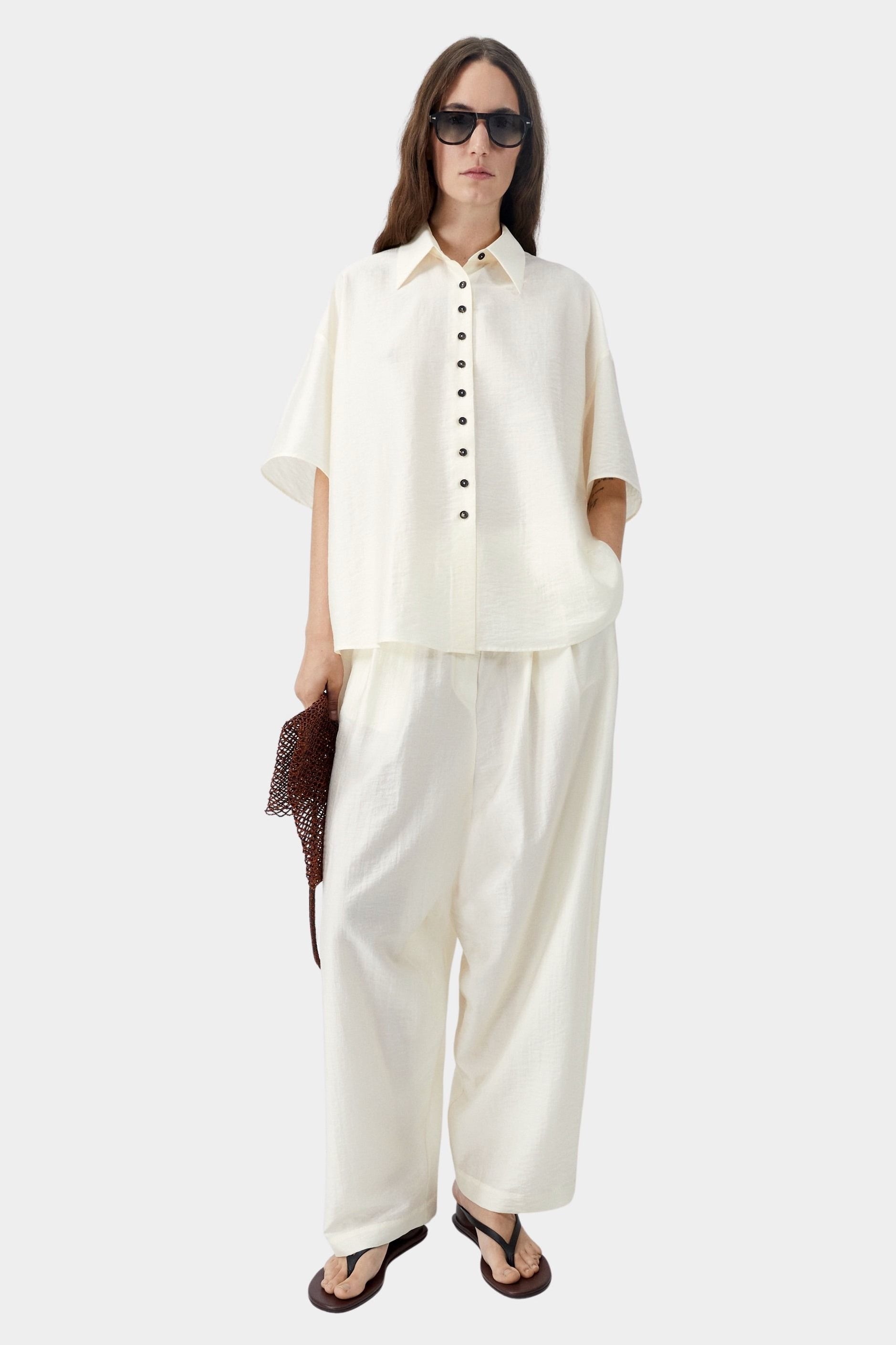Marfil cream short sleeve shirt with relaxed fit and button front, worn with matching wide leg pants