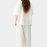 Cream oversized short sleeve shirt with clean back drape and relaxed silhouette, styled with matching set