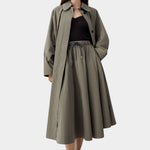 Vetiver green cotton technical midi skirt with elastic waist and drawstring, worn with black ribbed tank and sandals