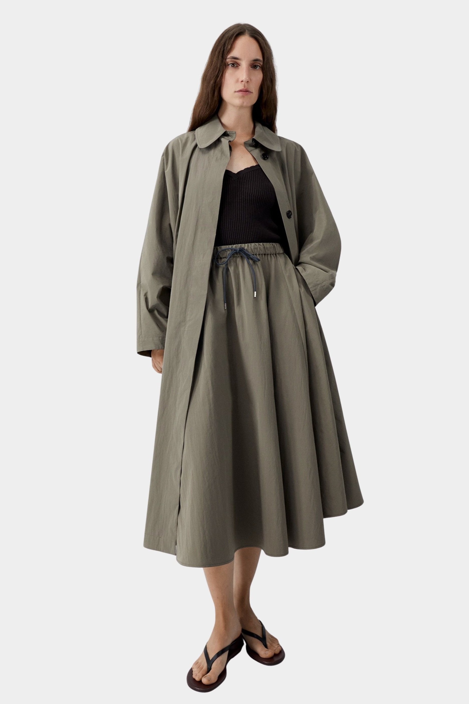 Vetiver green cotton technical midi skirt with elastic waist and drawstring, worn with black ribbed tank and sandals