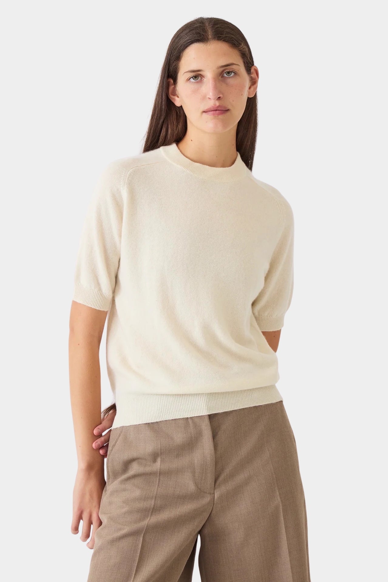Model wearing the ivory DEMYLEE Irelia cashmere top with short raglan sleeves and taupe trousers