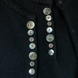 Close view of carved shell buttons on the black DEMYLEE Soleil cotton cardigan