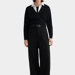 Kowtow Daily Shirt in white worn under black wrap sweater with wide leg trousers, full length view