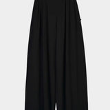 Front product view of the black Kowtow Drape Pant showing its pleats and full, wide legs.