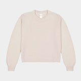 Flat lay of cream textured crewneck sweater with ribbed neckline, cuffs, and hem.