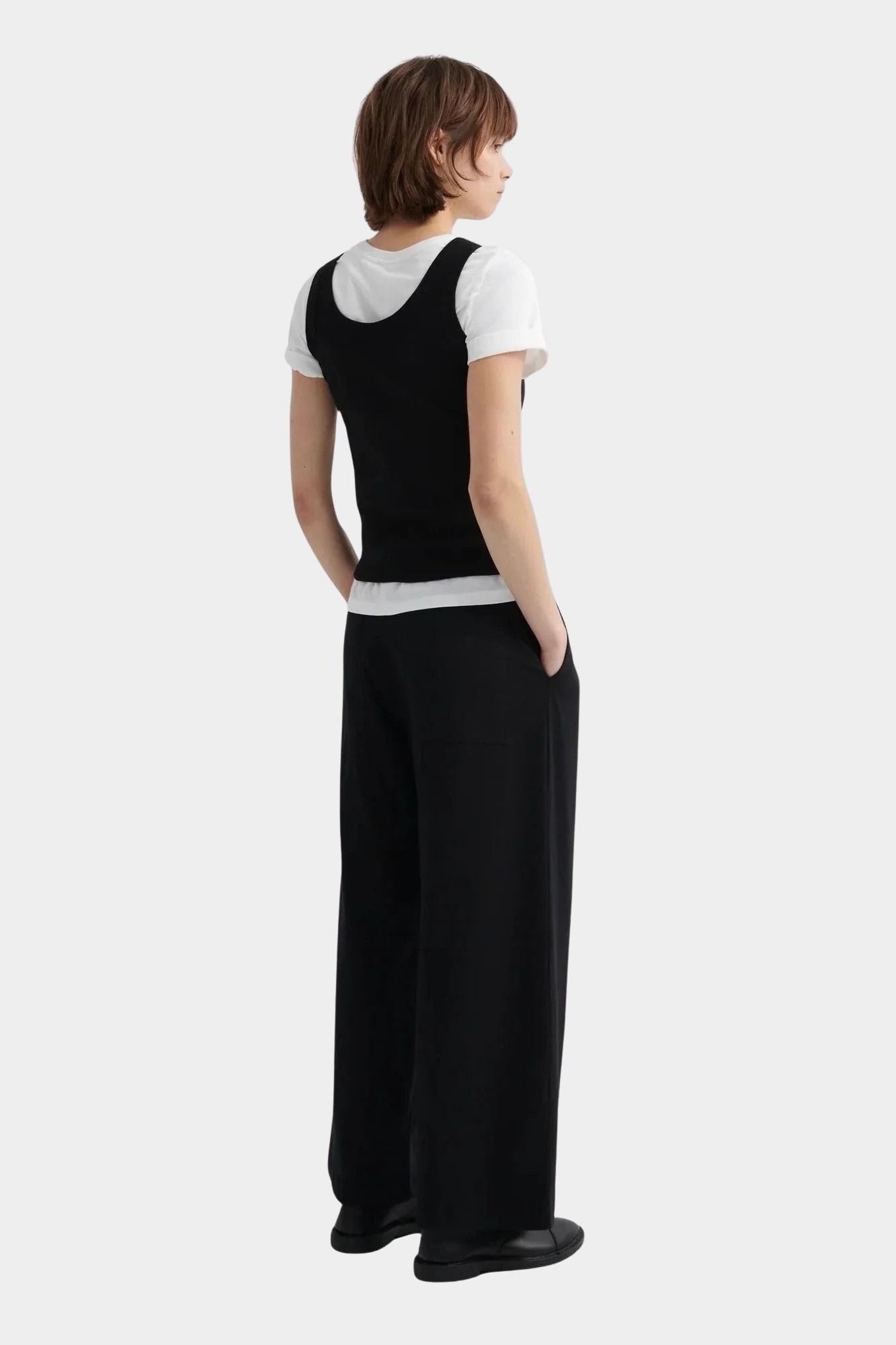 Kowtow Everyday Tank in black layered over white t shirt, back view