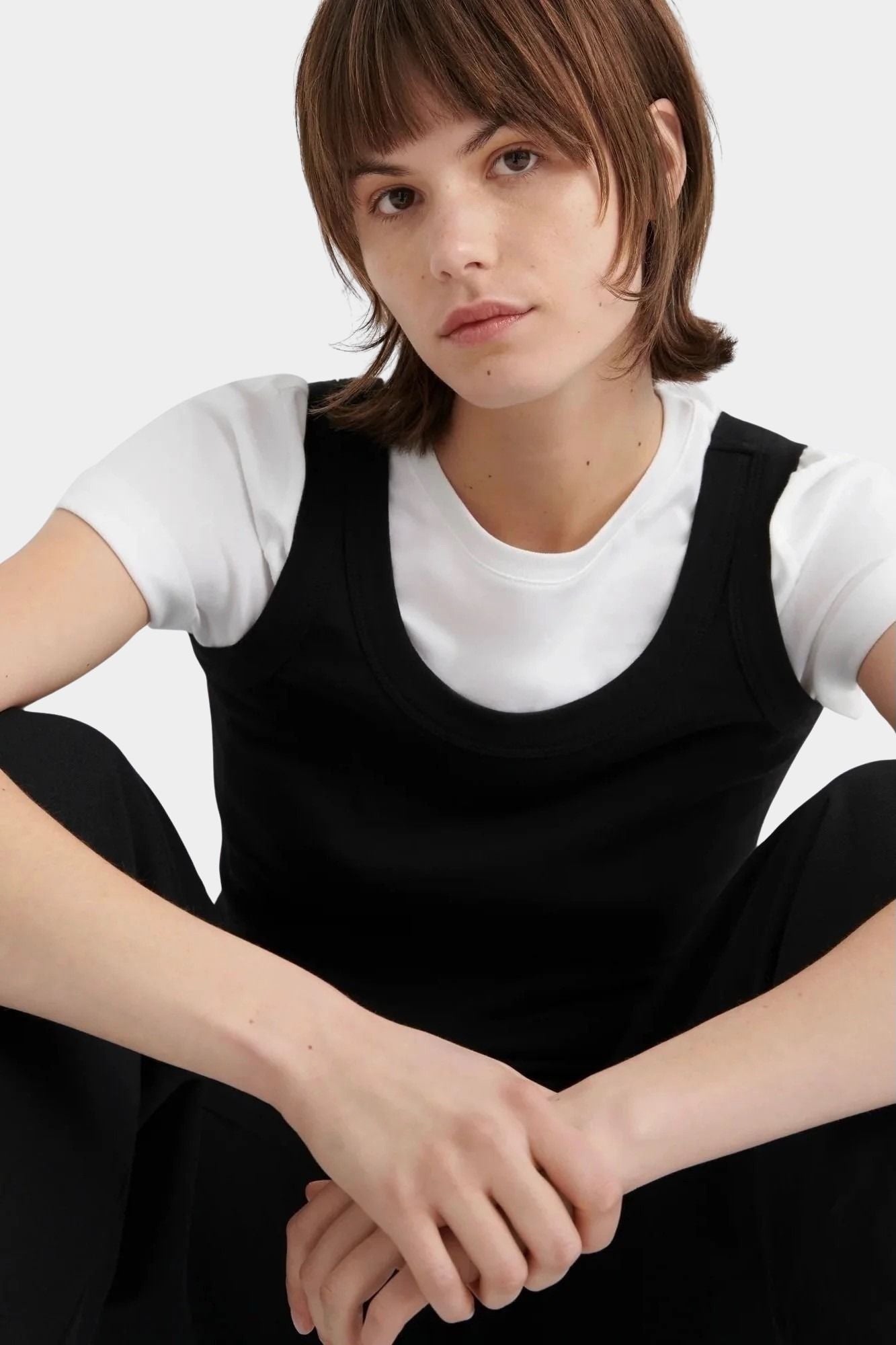 Kowtow Everyday Tank in black close up portrait view showing scoop neckline and wide straps