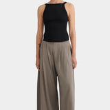 Model wearing the black Kowtow Low Back Cami with taupe wide leg trousers, full front view at YUCCA Denver.