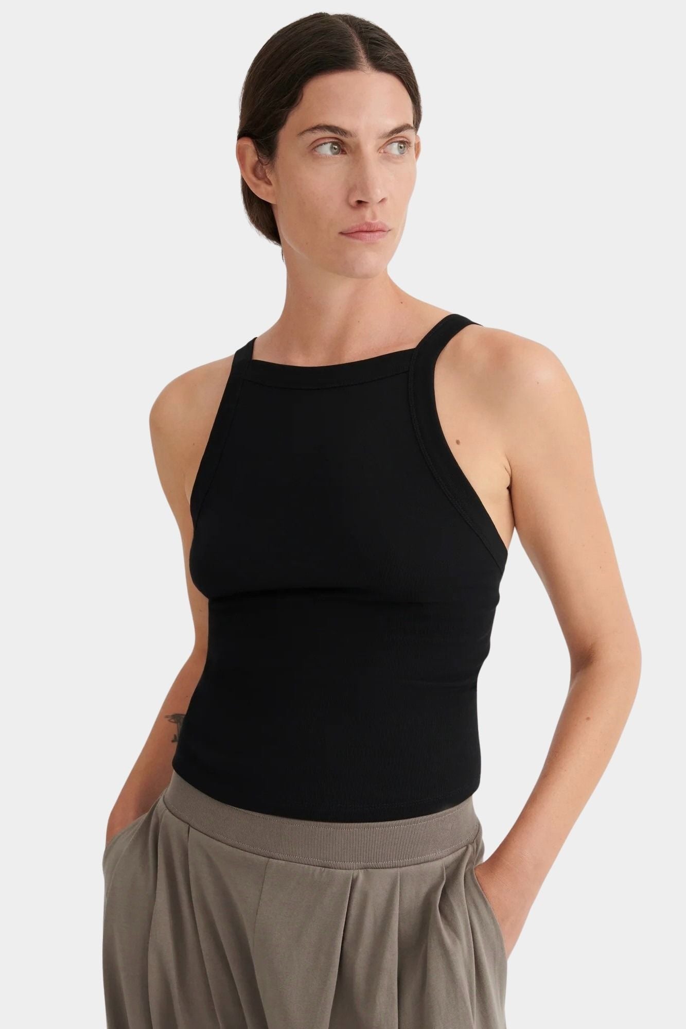 Close view of the black ribbed Kowtow Low Back Cami showing its high neckline and wide straps.