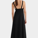 Back view of the black Low Back Dress showing its deep open back, shoulder straps, and flowing skirt