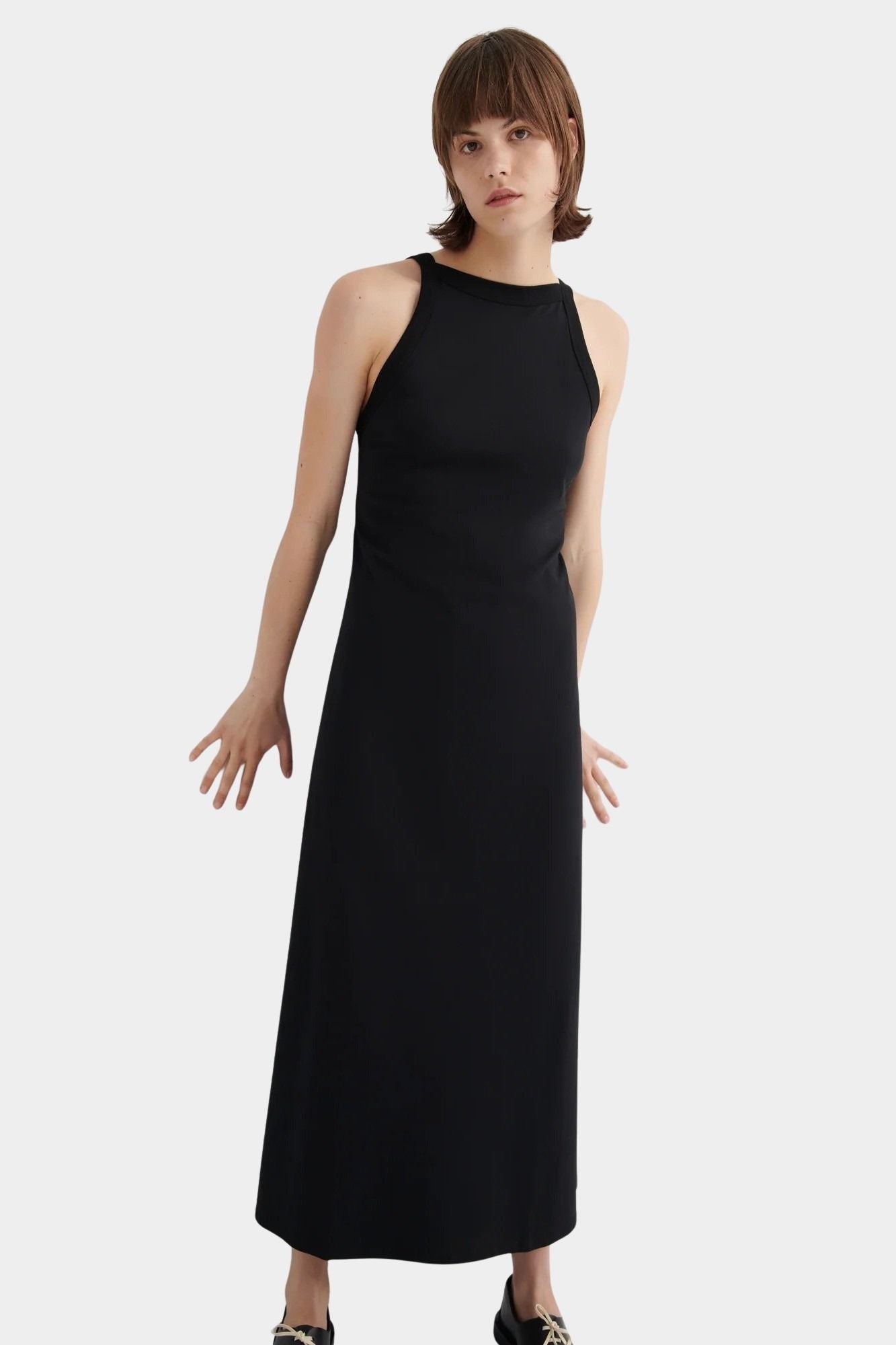 Kowtow Low Back Dress in black worn with black lace up shoes, angled front view