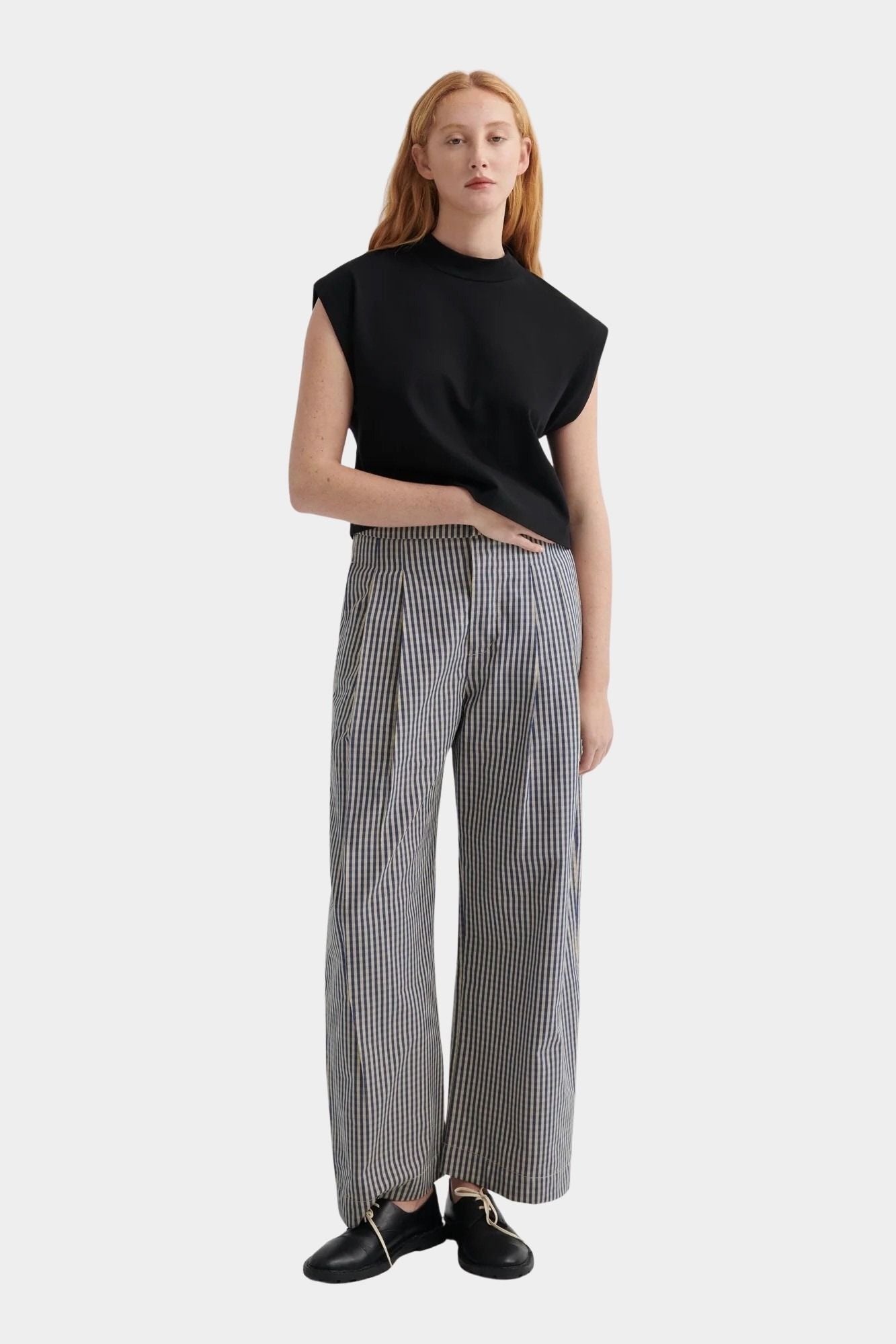 Kowtow Method Tank in black worn with striped wide leg trousers, full length view