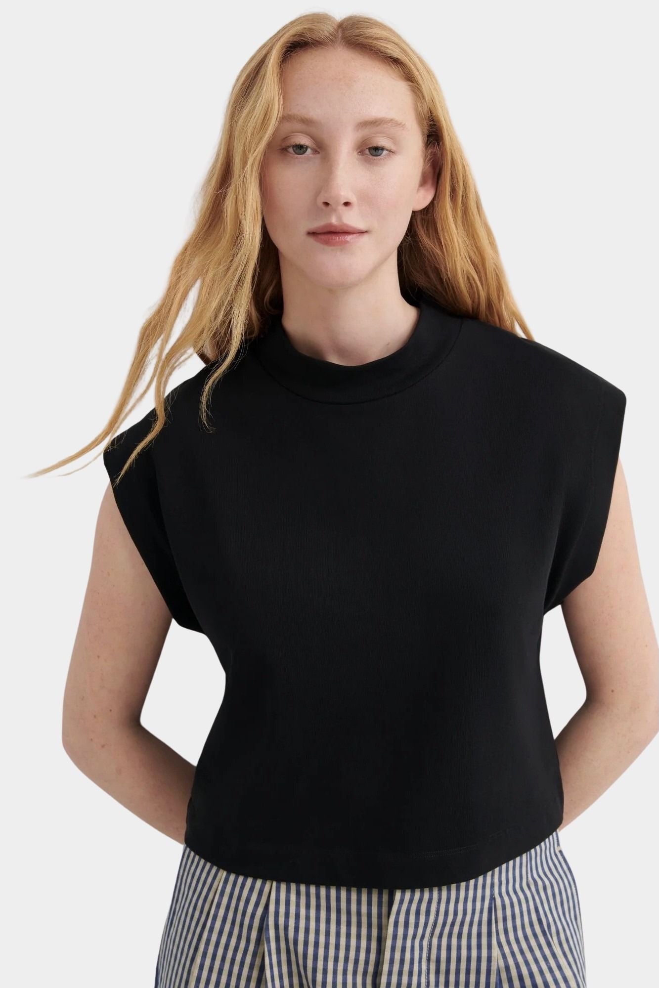 Kowtow Method Tank in black worn with striped wide leg trousers, front view