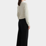 Kowtow Sailor Jeans in black worn with cream knit sweater, back view