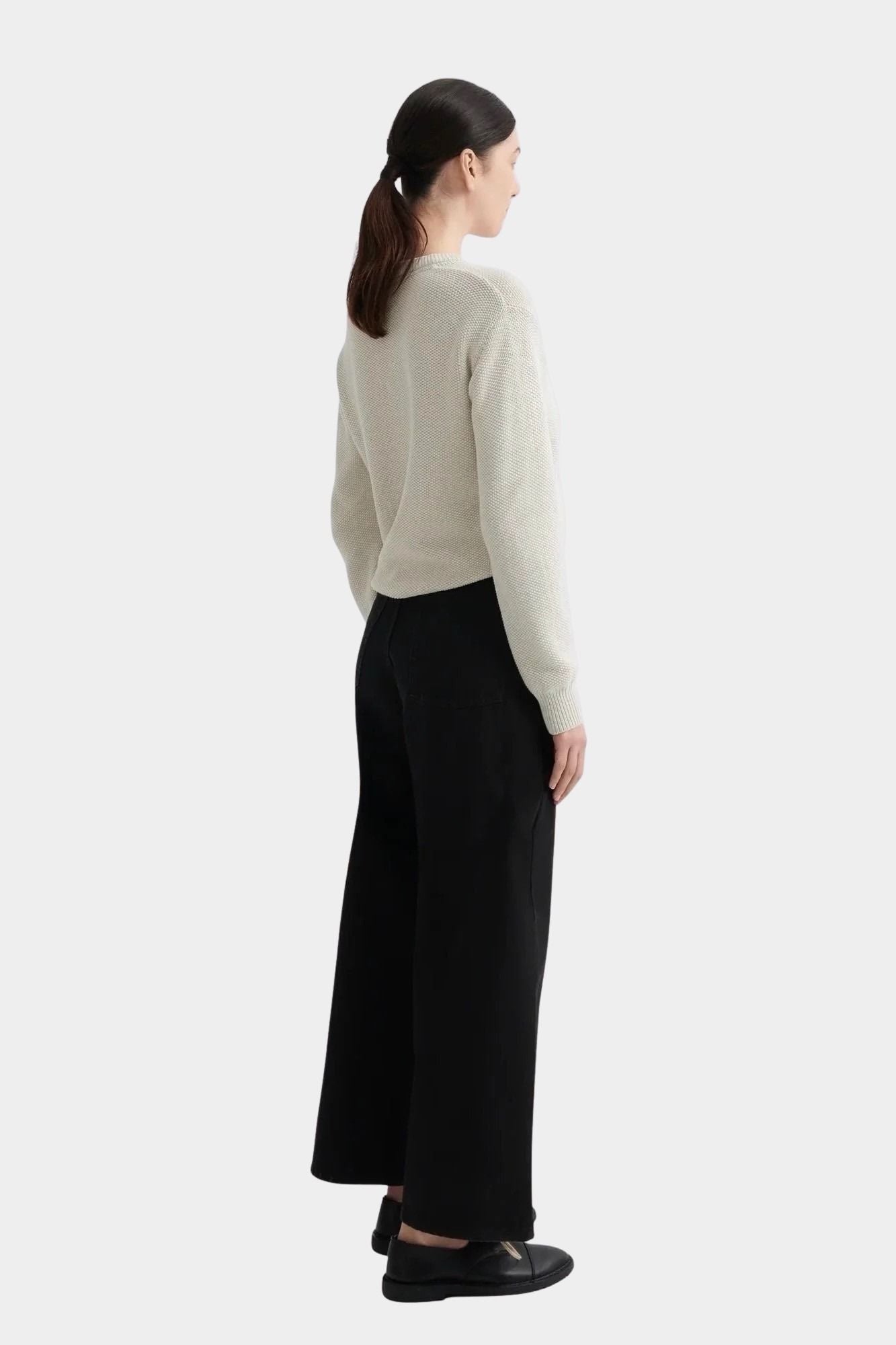 Kowtow Sailor Jeans in black worn with cream knit sweater, back view