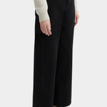Kowtow Sailor Jeans in black worn with cream knit sweater, side view showing wide leg silhouette