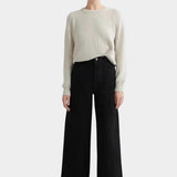 Kowtow Sailor Jeans in black worn with cream knit sweater, full length front view