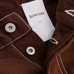 Kowtow Unity Jeans in brown denim close up interior label and metal button detail