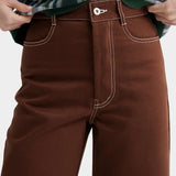Kowtow Unity Jeans in brown denim close up front view showing contrast stitching and button fly