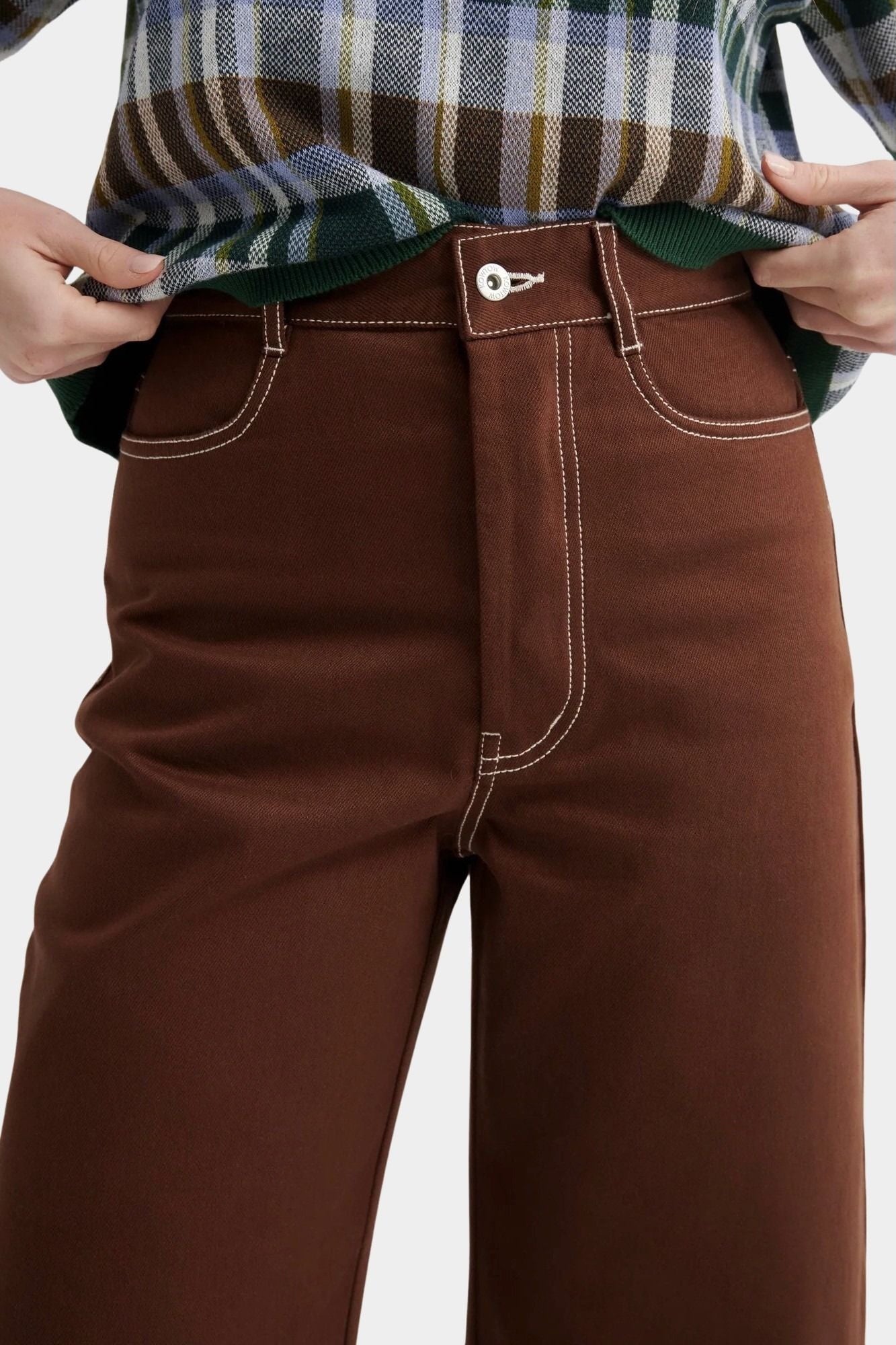 Kowtow Unity Jeans in brown denim close up front view showing contrast stitching and button fly