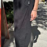 Side view of Le Bon Shoppe Arc Pants in black canvas highlighting the curved seam, roomy pocket and sculptural silhouette.